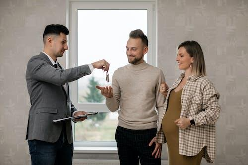 Free A Real Estate Agent Handing the Key to the New Homeowners Stock Photo
