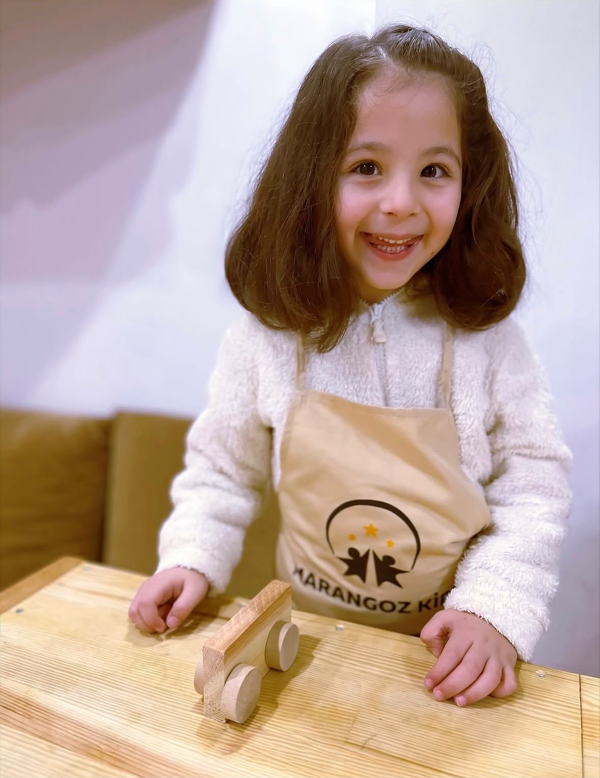 Marangoz Kids Akademi çocuk ahşap atölyesinde önlük giyerek ahşap oyuncak hazırlayan çocuk